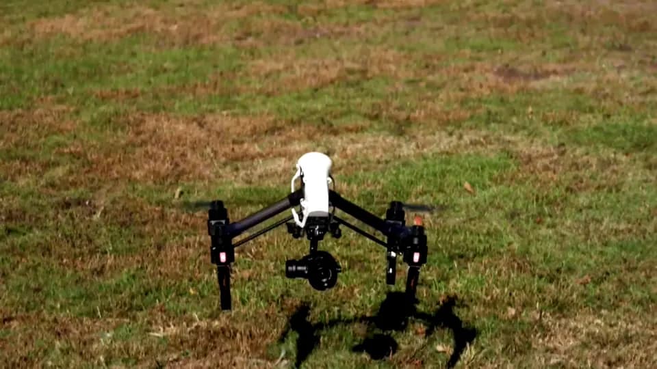 A drone lifting off from grass